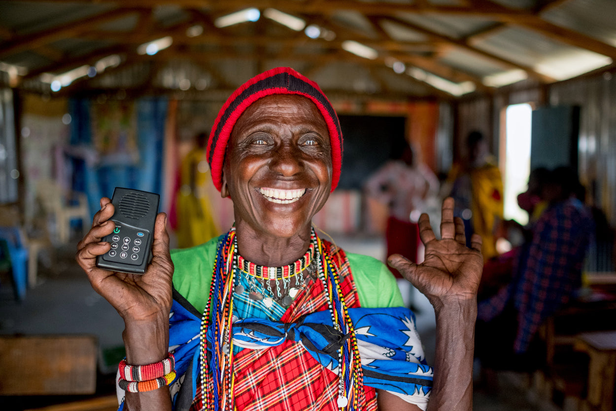 a smiling woman holding a solar audio bible