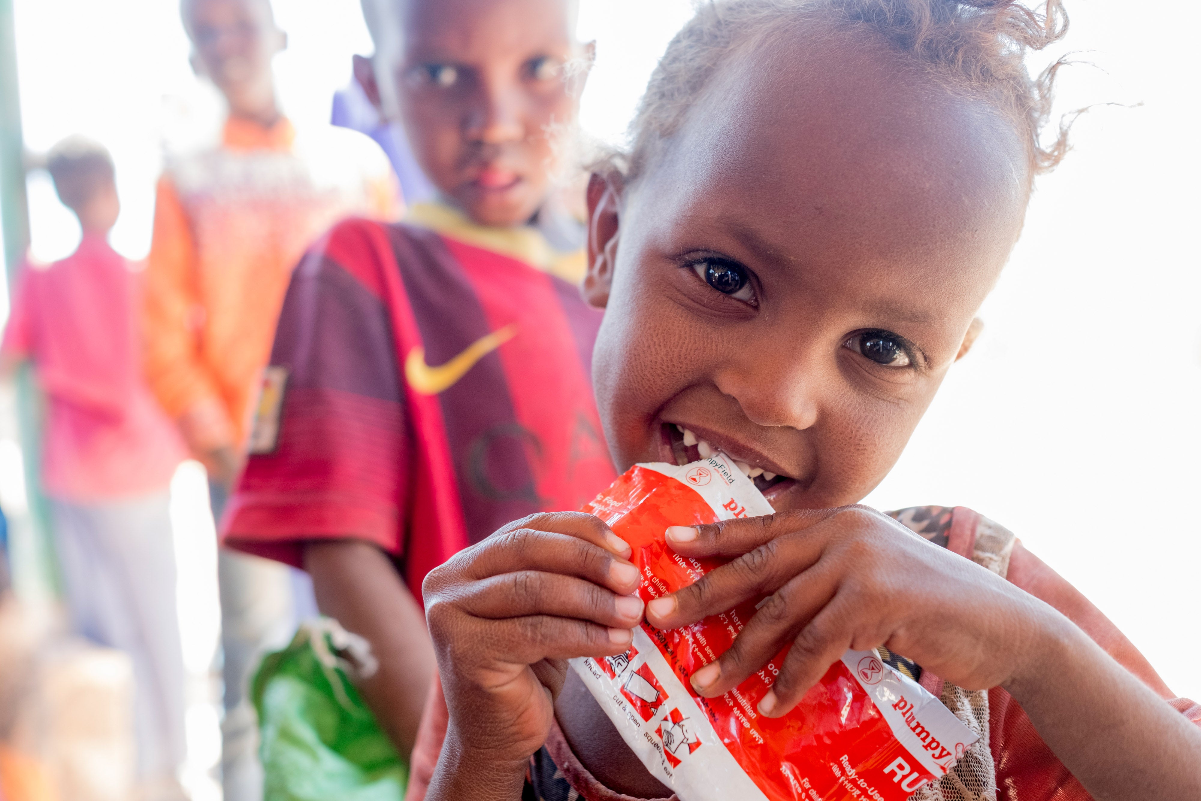 a little girl eating an emergency nutrition packet