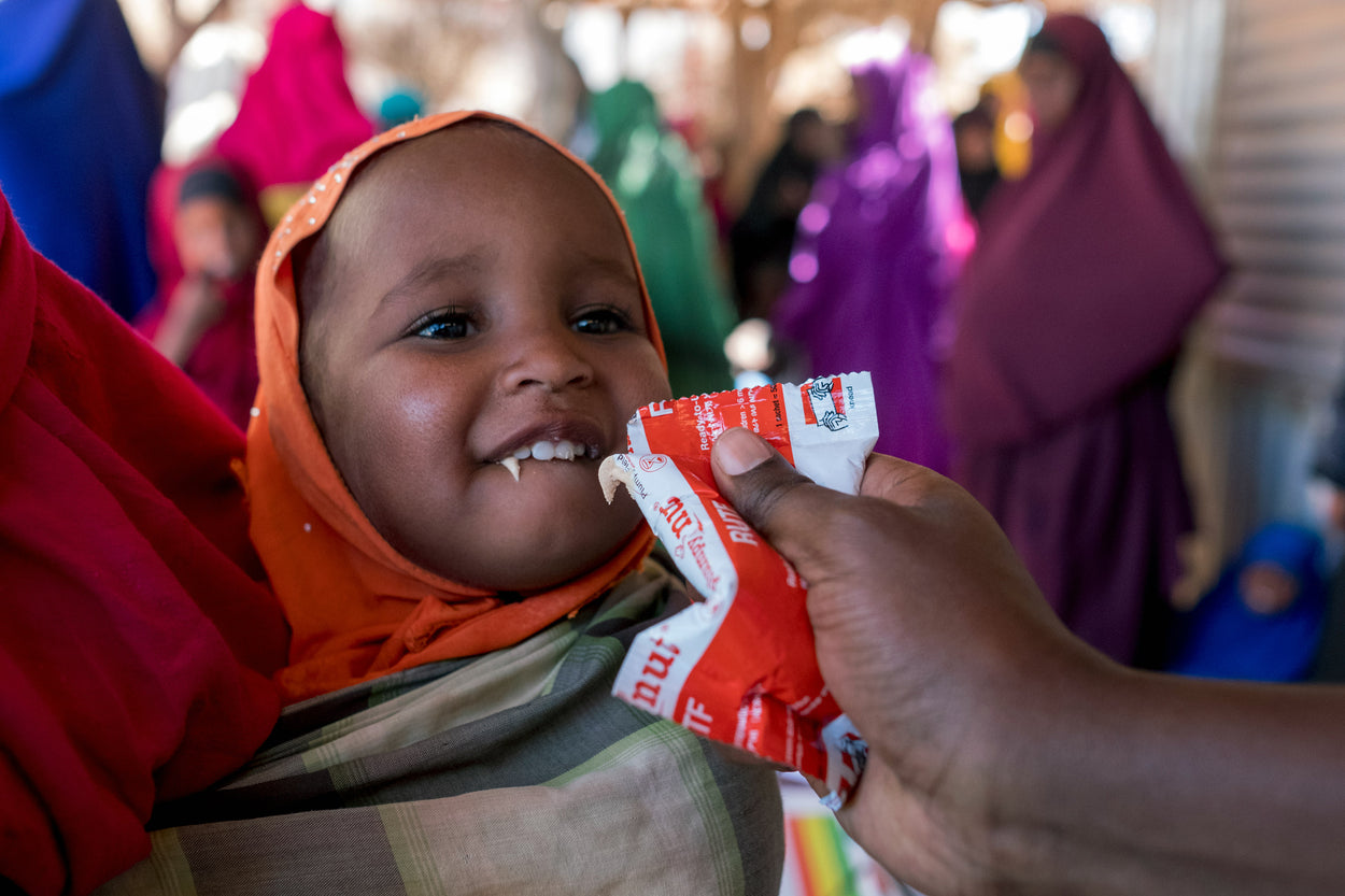 A baby eats an emergency nutrition packet.