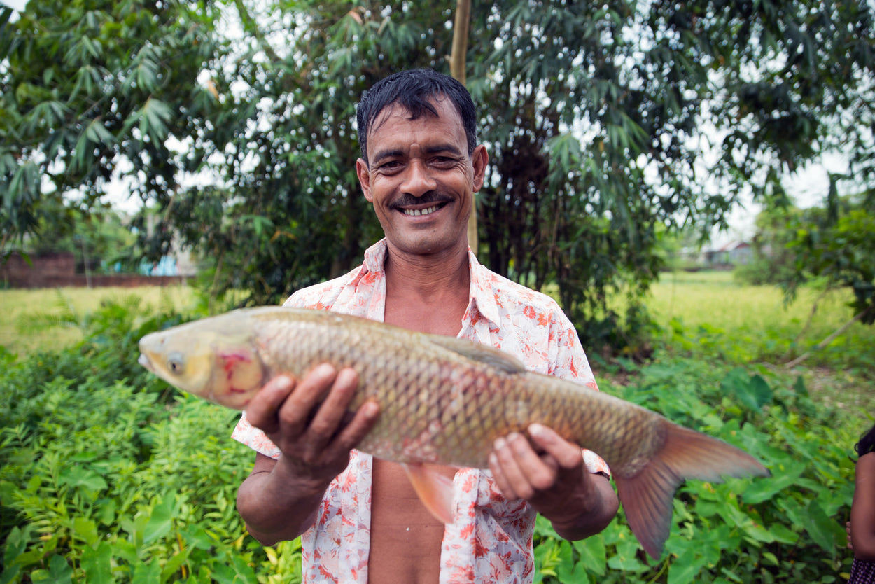 A fisherman holds up a fish.