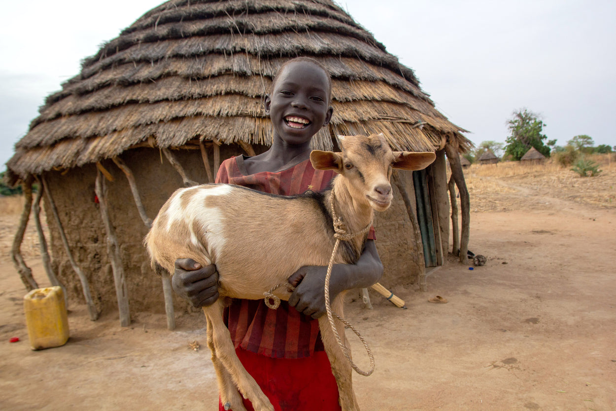 Tevin smiles as he holds a goat he received from World Concern.