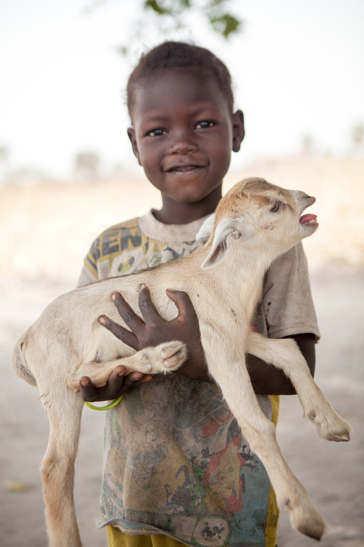 A kid holding his kid goat.