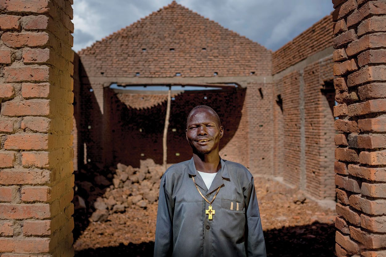 A pastor stands in front of his church that's being built.