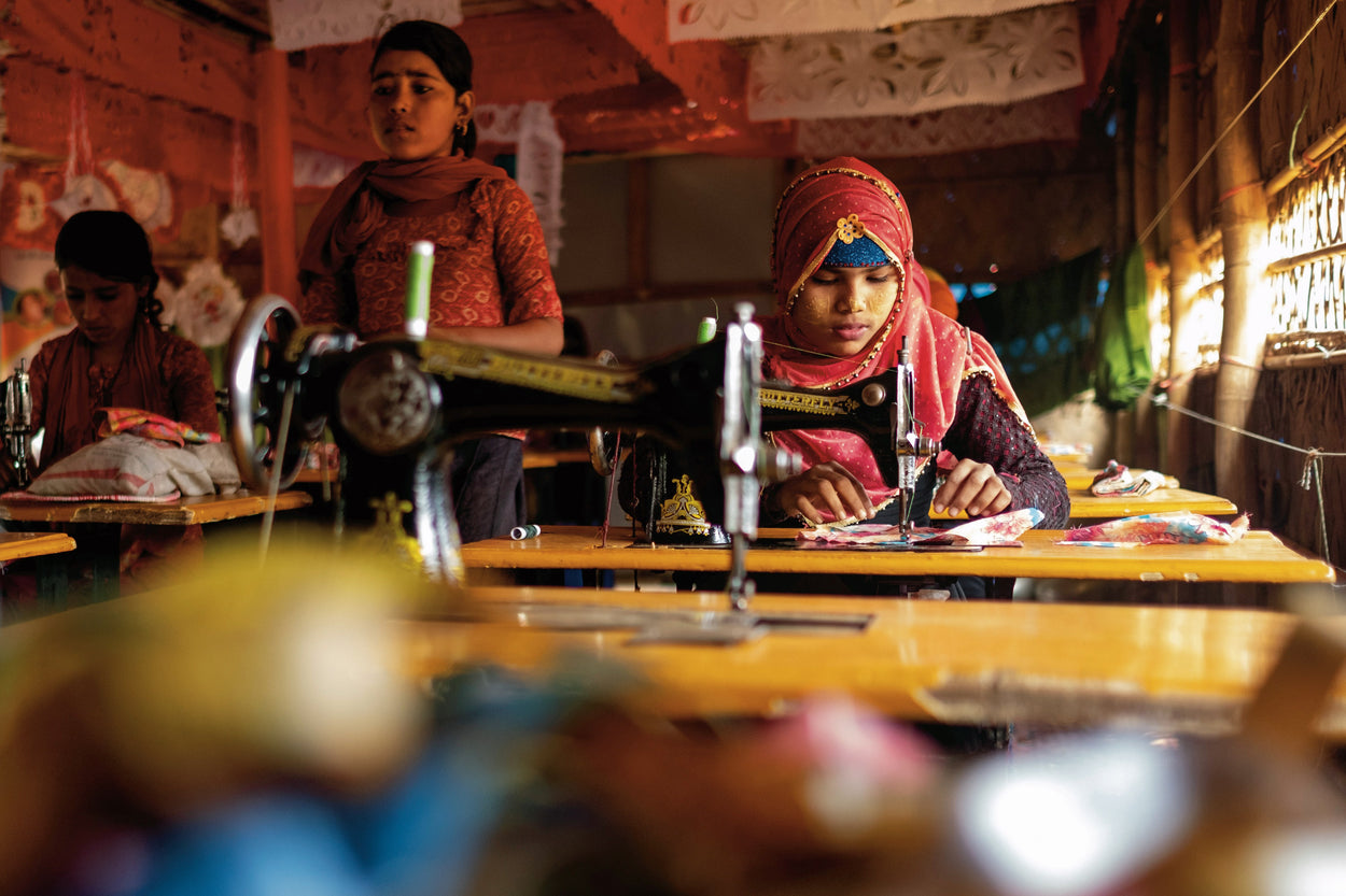 A woman works at her sewing machine.