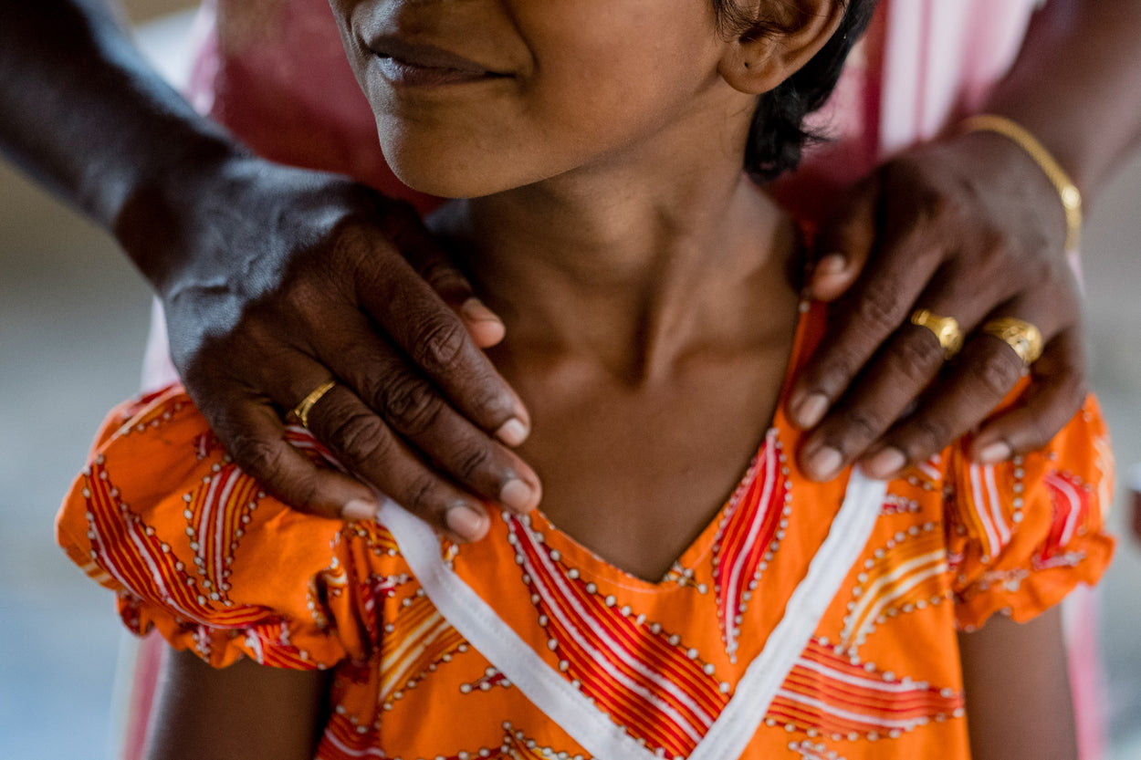 a woman's hands on a little girl's shoulders 